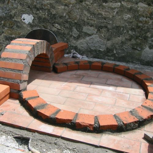 La paroi ronde du four est constituée de briques coupées en deux.